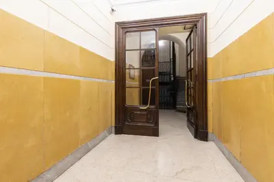 an empty hallway with a wooden door in a building at Hostly-Puccini Luxury Home-Near Colosseum & Trevi in Rome