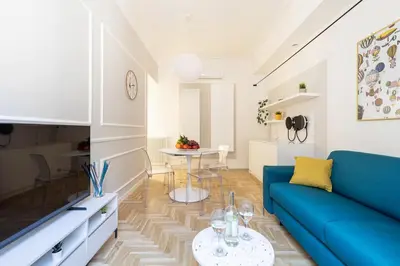 a living room with a blue couch and a table at Hostly-Puccini Luxury Home-Near Colosseum & Trevi in Rome