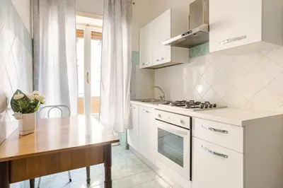 a white kitchen with a table and a stove at Dolce vita romana in Rome