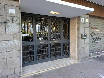 a front door of a building with black doors at Rome Lumina - Bilocale luminoso vicino Metro C, 6 fermate dal Colosseo in Rome