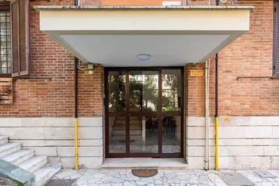 an entrance to a brick building with a large glass door at Brunetta Cozy Apartment-Metro B in Rome