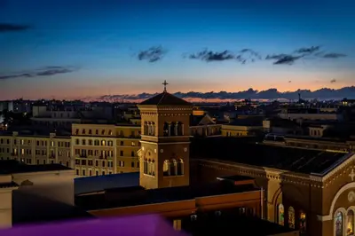 a clock tower on top of a building at sunset at Lyo Sky Rooms in Rome
