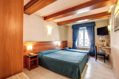 a bedroom with a blue bed in a room at Hotel Verona Rome in Rome