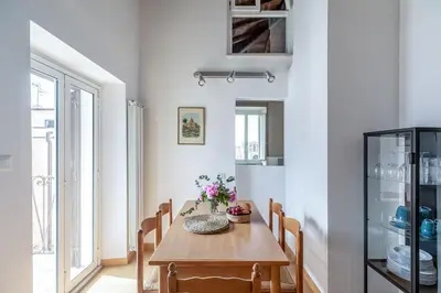 a dining room with a wooden table and chairs at Hostly-Light and Wood Rome Midtown-Near Trevi in Rome