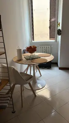 a table and chairs in a room with a window at Retroflatsanlorenzo in Rome