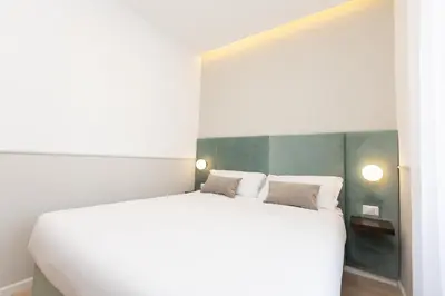 a bedroom with a large white bed with two pillows at Vatican Colors Rooms in Rome