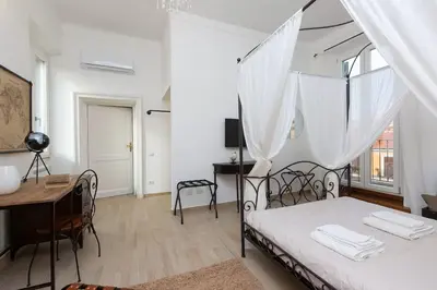 a bedroom with a bed and a desk and a table at Iron Apartment Santa Maria in Rome