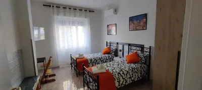 a bedroom with two beds and a table and a window at Malagrino House in Rome