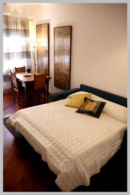 a bedroom with a bed with a table and a dining room at Holiday Rome Apartment in Rome