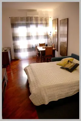 a bedroom with a bed and a dining room with a table at Holiday Rome Apartment in Rome