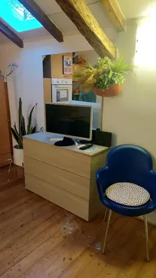 a desk with a computer and a blue chair at Loft at Ponte Milvio in Rome