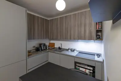 a kitchen with white cabinets and a counter top at Trastevere Luxury Apartment in Rome