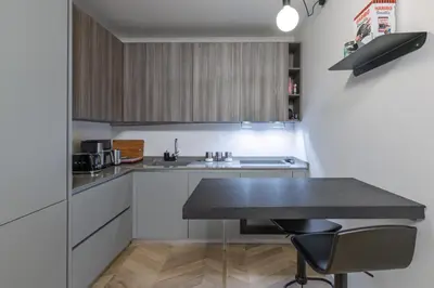 a kitchen with a black counter top and a table at Trastevere Luxury Apartment in Rome