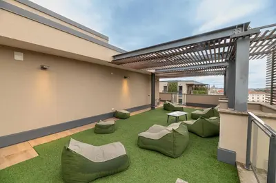a rooftop patio with green grass and furniture on a building at Trastevere Luxury Apartment in Rome