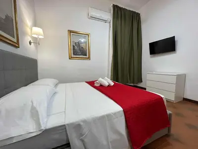 a bedroom with a white bed with a red blanket at 888 Vittorio in Rome