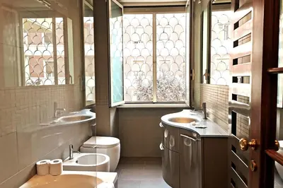a bathroom with two sinks and a toilet and a window at Superior Vatican suite Key Apartment in Rome