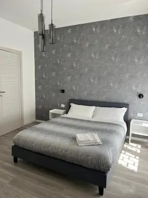 a bedroom with a large bed with a wall at Tiburtina Urban Rooms in Rome