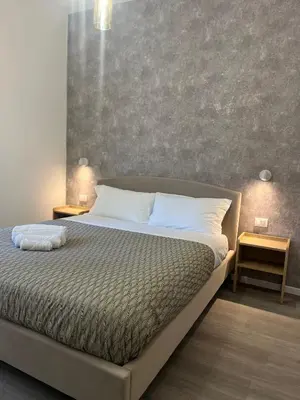a bedroom with a large bed with two night stands at Tiburtina Urban Rooms in Rome