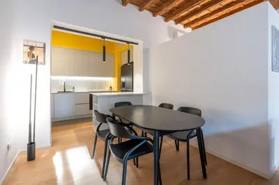 a kitchen and dining room with a black table and chairs at Sotto al letto del Papa - Borgo Pio - Vaticano in Rome