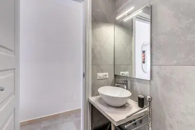 a bathroom with a white sink and a mirror at Boezio 6 Rooms by Roman Dreams in Rome