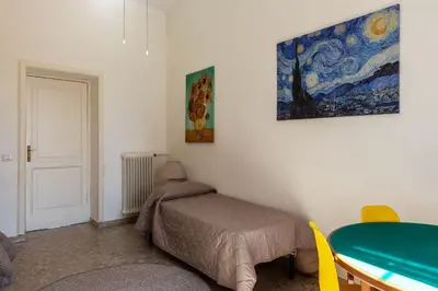 a bedroom with a table and a painting on the wall at GuestHost - San Lorenzo Bright Apartment X8 in Rome