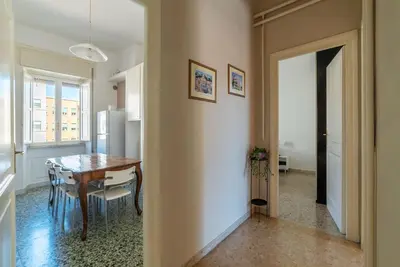 a kitchen and dining room with a table and a dining roomiasm at GuestHost - San Lorenzo Bright Apartment X8 in Rome