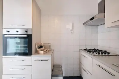 a kitchen with white cabinets and a stove top oven at Vaticano - Giubileo - A 2 passi da San Pietro by Hôtea in Rome