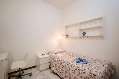 a small bedroom with a bed and a chair at Vaticano - Giubileo - A 2 passi da San Pietro by Hôtea in Rome
