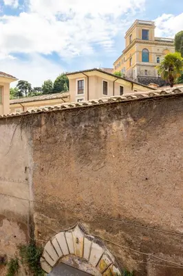 an old stone wall with an arch in front of a building at Panieri Apt - Homkeey Apartments in Rome