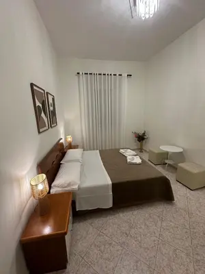 a bedroom with a large bed and a table at Alloggio Turistico Eli in Rome
