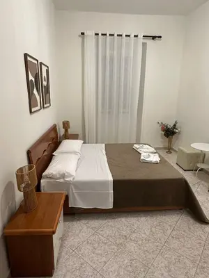 a bedroom with a bed and a table and a window at Alloggio Turistico Eli in Rome