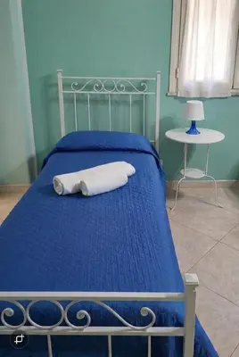 a blue bed with a white towel on it at B&B La Casa di Gabry in Rome