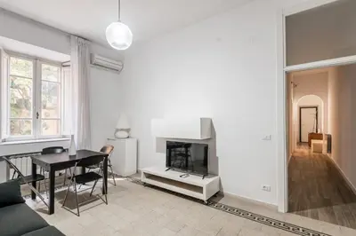 a living room with a table and a fireplace at iFlat Mid-Century Modern Vatican Apartment in Rome