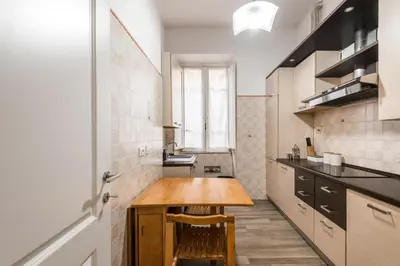 a small kitchen with a wooden table in it at iFlat Mid-Century Modern Vatican Apartment in Rome