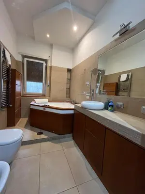 a bathroom with two sinks and a tub and a toilet at Charm Apartment & Relax Jacuzzi Roma-Gemelli in Rome