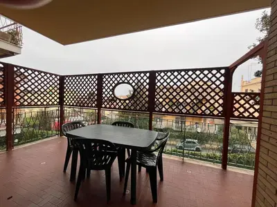 a table and chairs in a room with a large window at Charm Apartment & Relax Jacuzzi Roma-Gemelli in Rome