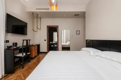 a bedroom with a large white bed and a desk at Hotel Valeri in Rome