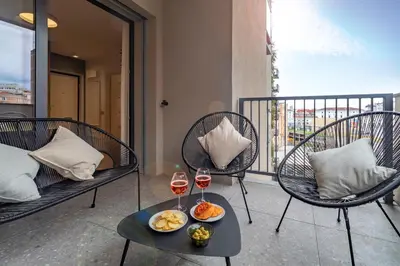 a balcony with two chairs and a table with wine glasses at AureaLiving - Sage luxury apt with Air Conditioning, Fast Wifi and free Gym in Rome