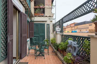 a balcony of a house with a table and chairs at The Best Rent - One-bedroom apartment in a quiet, classically styled corner near the Quirinale in Rome