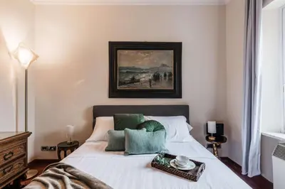 a bedroom with a bed with a painting on the wall at The Best Rent - One-bedroom apartment in a quiet, classically styled corner near the Quirinale in Rome