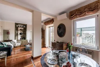 a living room with a table and a large window at The Best Rent - One-bedroom apartment in a quiet, classically styled corner near the Quirinale in Rome