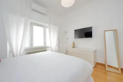 a white bedroom with a white bed and a mirror at YCH-Nice flat with patio near Vatican in Rome