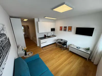 a living room with a blue couch and a kitchen at GioLu Colosseo in Rome