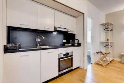 a kitchen with white cabinets and a sink and a stove at Vivilo Collection - Loft Santo Spirito in Rome