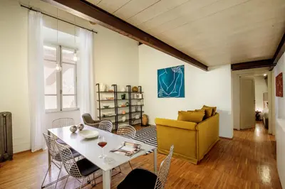 a living room with a table and a yellow chair at Liberti Colosseo - Luxury Apartment in Rome