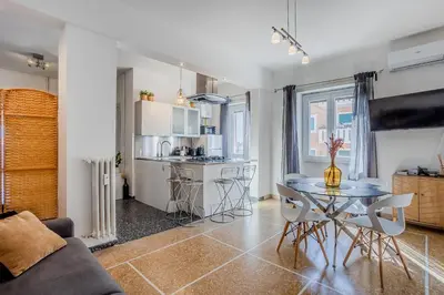 a living room with a table and a kitchen at Amor Rome Apartment & Suites in Rome