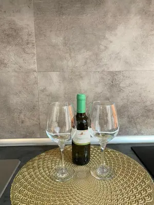 two wine glasses and a bottle of wine on a table at Easy Suite Roma San Pietro in Rome