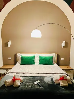 a bedroom with a large bed with green pillows at Luminosa House Roma Central Station in Rome