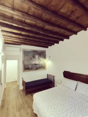 a bedroom with a bed and a painting on the wall at Roman Forum Rooms in Rome