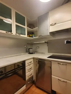 a kitchen with stainless steel appliances and white cabinets at Laterano Home in Rome